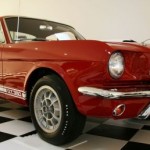 A red ford mustang sits on a checkered floor.