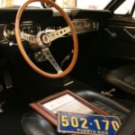 The interior of a classic car with a steering wheel and steering wheel.