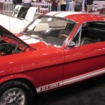 A red ford mustang is on display at a show.