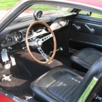 The interior of a classic car with leather seats and steering wheel.