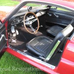 The interior of a red mustang is open.