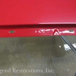 A close up of a red metal table with a hole in it.