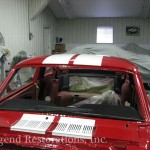 The back of a red car in a garage.