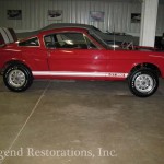 A red mustang is parked in a garage.