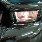 A close up of a chrome headlight on a car.