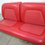 A pair of red leather seats in a garage.