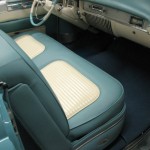 The interior of a classic car is blue and white.