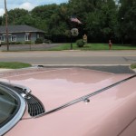 The hood of a pink car.