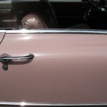 The door handle of a pink car.