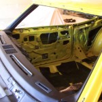 The inside of a yellow car with the door open.