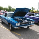 A blue muscle car parked in a parking lot.