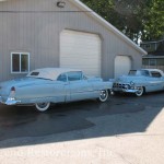 Two blue and white color cars in front of a building