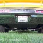 The rear end of a yellow muscle car.