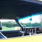 The interior of a yellow car with a sunroof.