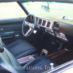 The interior of a yellow car with leather seats and steering wheel.