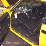 The interior of a yellow muscle car.