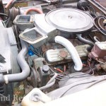 The engine compartment of a yellow car.