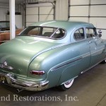 Back view of green color car for repair on the display