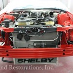 A red mustang engine in a garage.