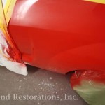 A red car is being painted with paint.