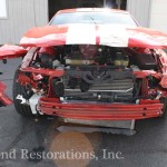 A red and white car with its hood open.