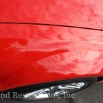 A red car is parked in a parking lot.